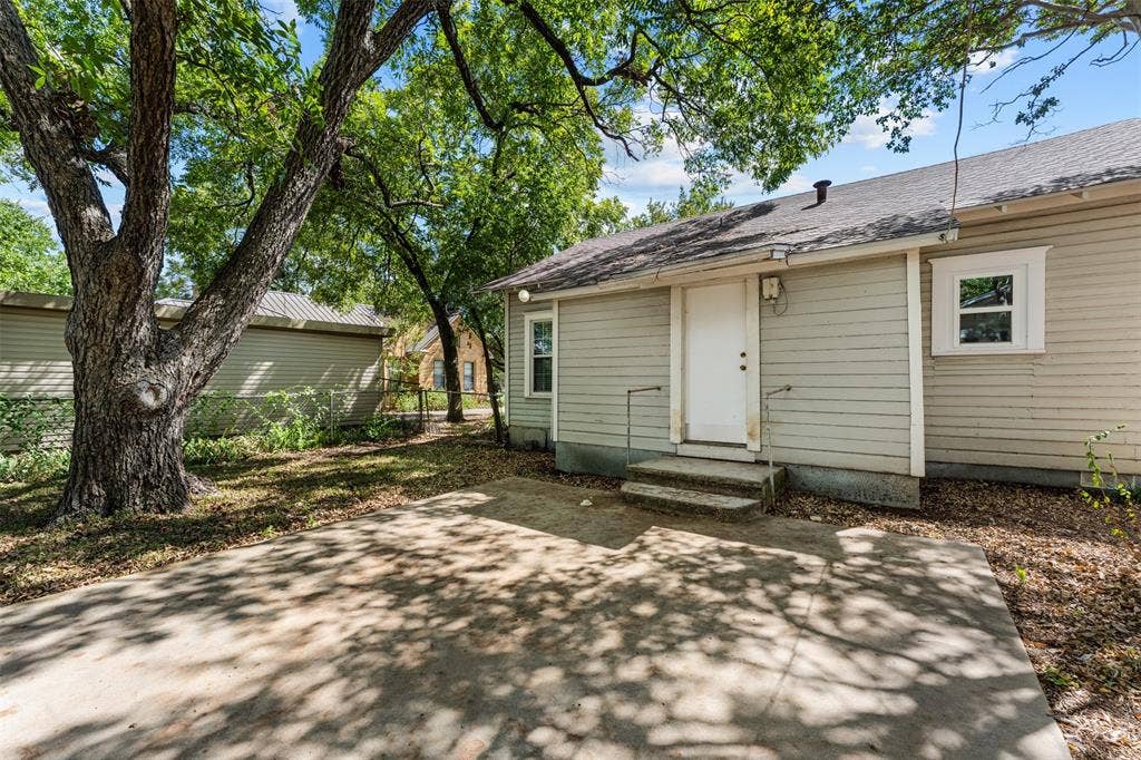 302 W Broadway Street, West, TX 76691 Concrete patio area with mature trees providing dappled shade