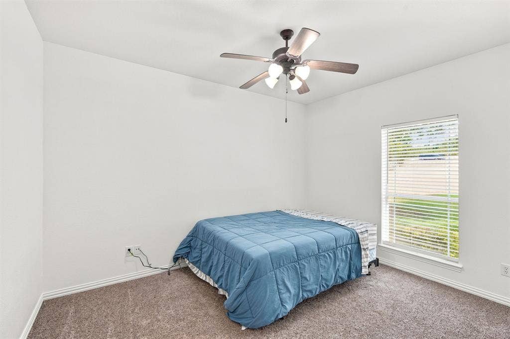 Airy bedroom featuring  neutral tones, and textured carpeting for comfort.