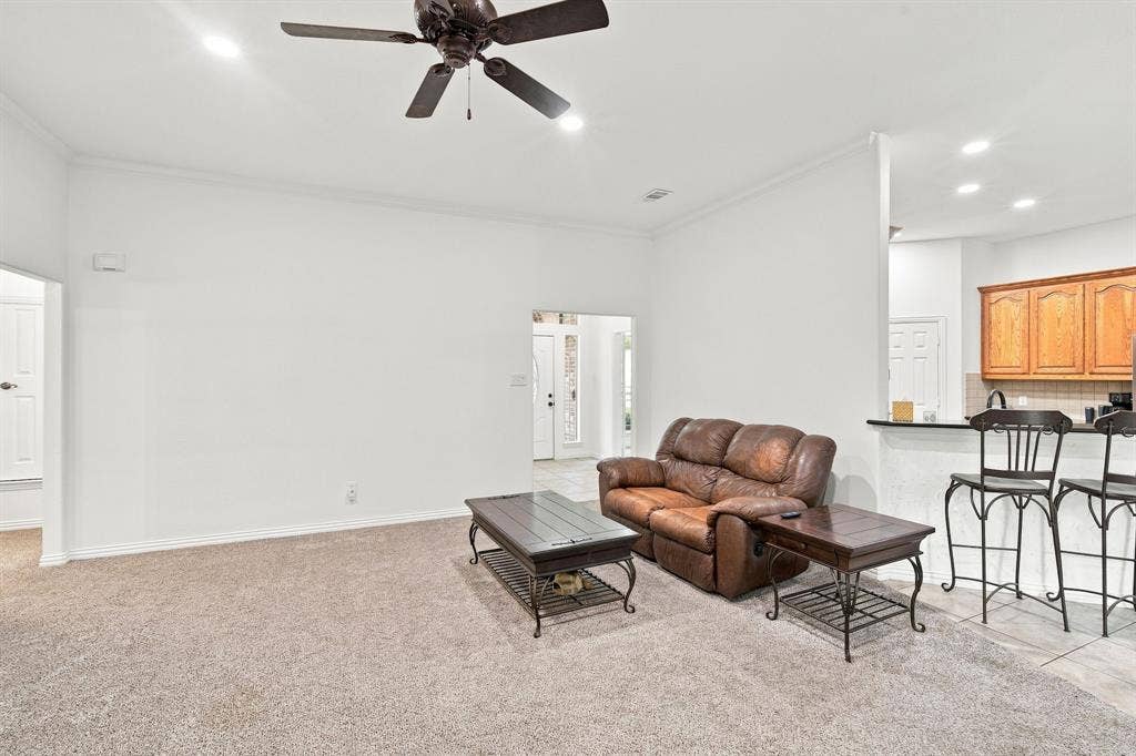 Bright, open living area with recessed lighting, a ceiling fan, and a convenient breakfast bar for casual entertaining.