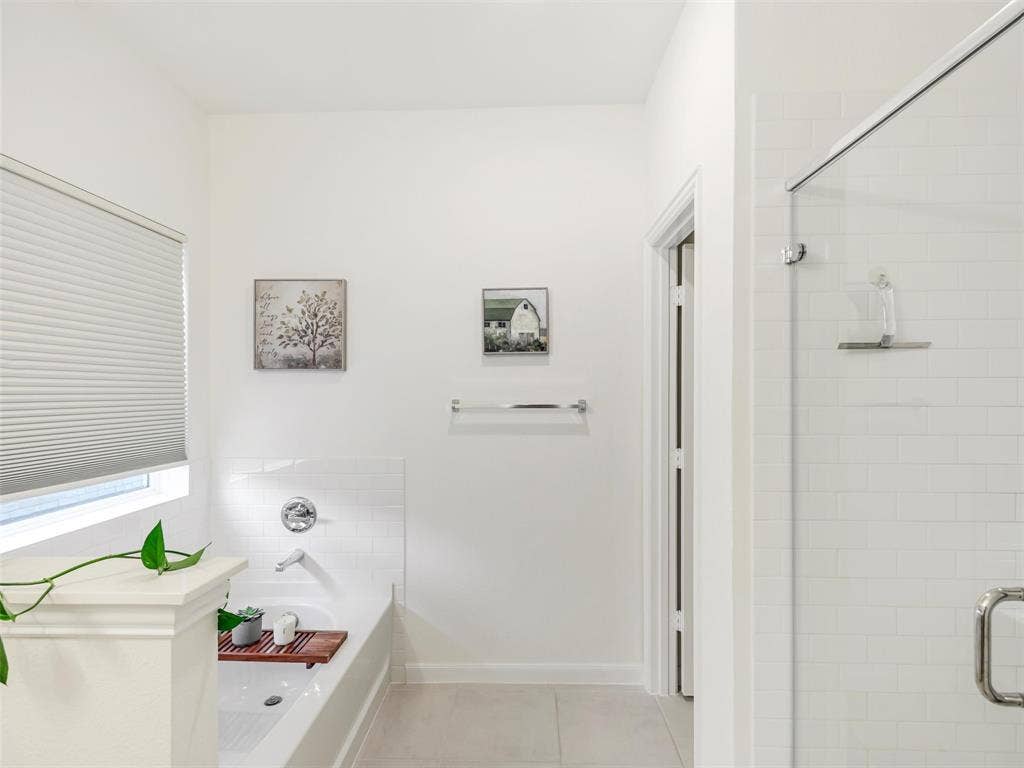 White subway tile shower surround with clear glass enclosure and chrome hardware