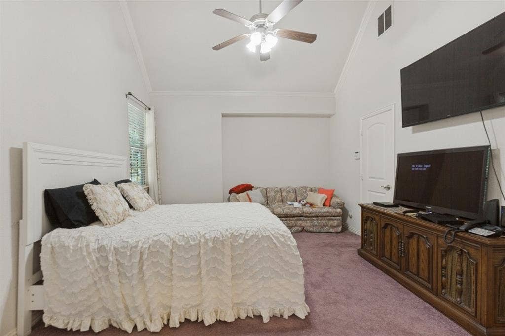 524 S Greenville Avenue, Richardson, TX 75081 Vaulted ceiling with ceiling fan, window with blinds, and wall-to-wall carpeting.