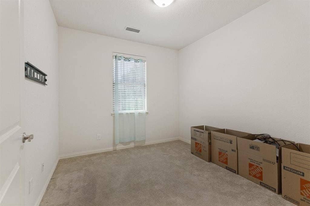 524 S Greenville Avenue, Richardson, TX 75081 Neutral-toned wall finishes, light-toned carpeting, and a window with blinds provide a neutral foundation