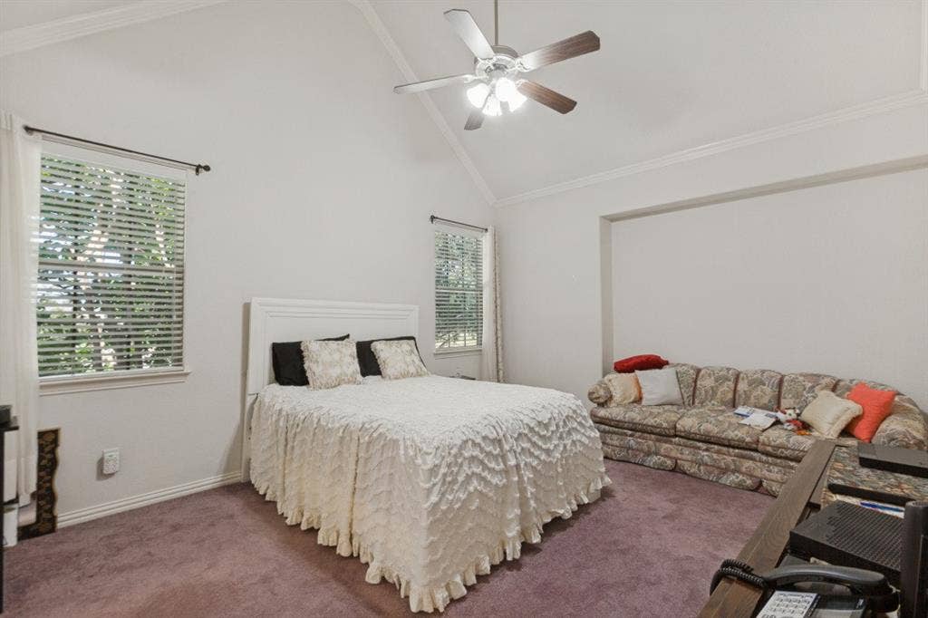 524 S Greenville Avenue, Richardson, TX 75081 Primary Bedroom featuring a vaulted ceiling, ceiling fan, crown molding, double windows with blinds, and recessed space with enough room for a sitting area.