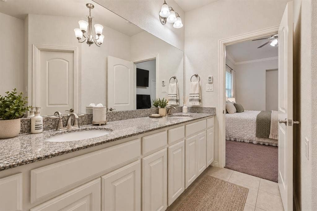 524 S Greenville Avenue, Richardson, TX 75081 Dual vanity with stone-finish countertops, undermount sinks, and white shaker-style cabinetry