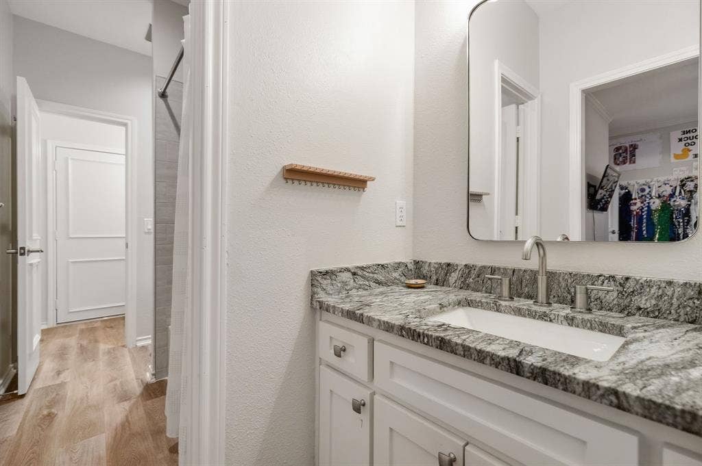 5748 Clarendon Drive, Plano, TX 75093 Jack & Jill bathroom with updated cabinetry, granite counters, flooring & shower tile.