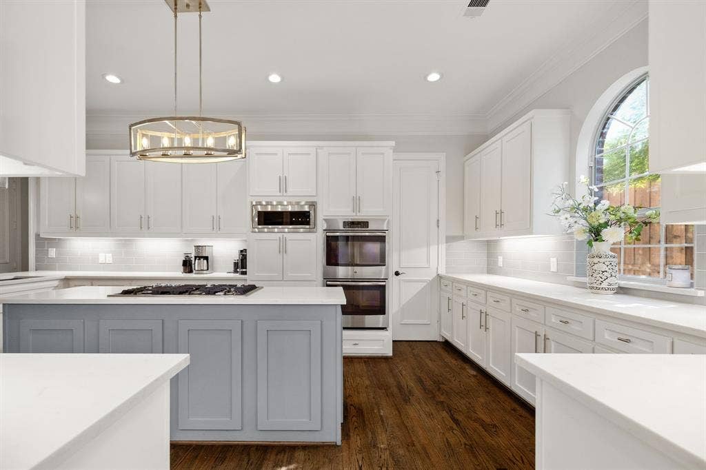 5748 Clarendon Drive, Plano, TX 75093 White quartz counters, custom cabinetry with spice storage, double ovens, built-in microwave.