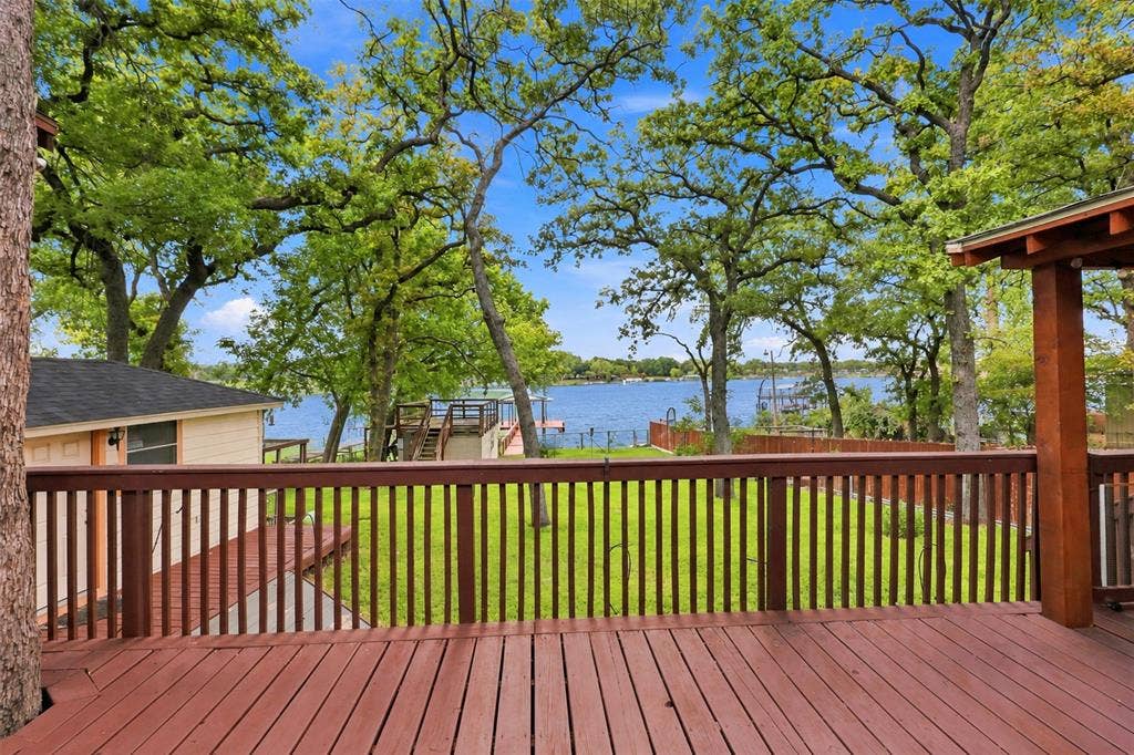 284 Shoreline Drive N, Azle, TX 76020 Expansive wood-finish deck with railing, surrounded by mature trees, overlooking a body of water