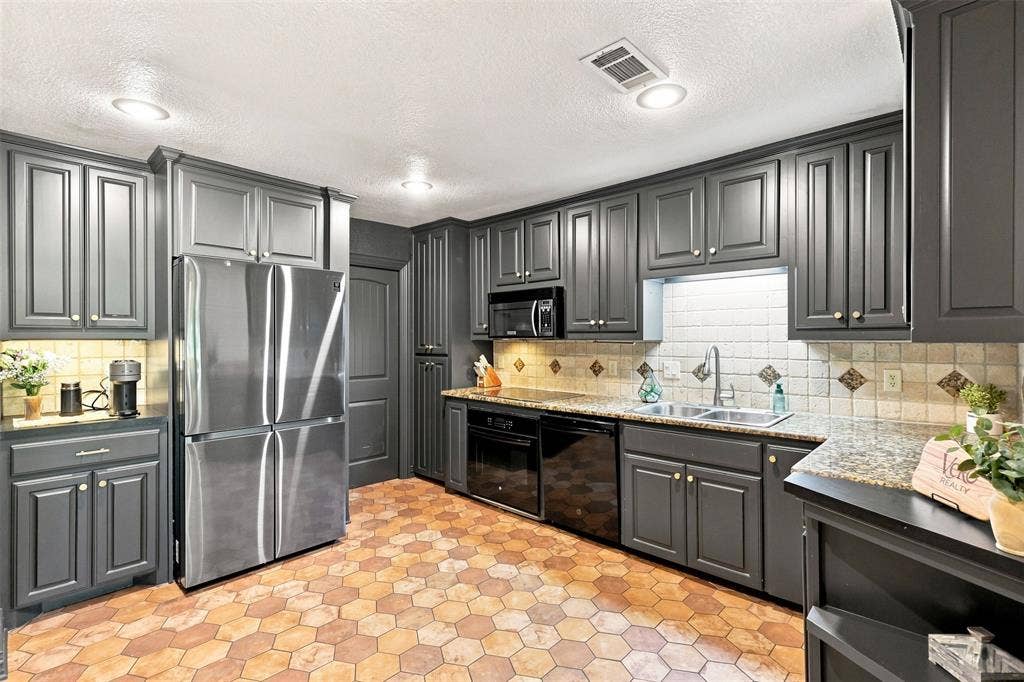 284 Shoreline Drive N, Azle, TX 76020 Kitchen featuring dark-toned cabinetry, hexagonal floor tile, recessed lighting, and a stainless steel refrigerator