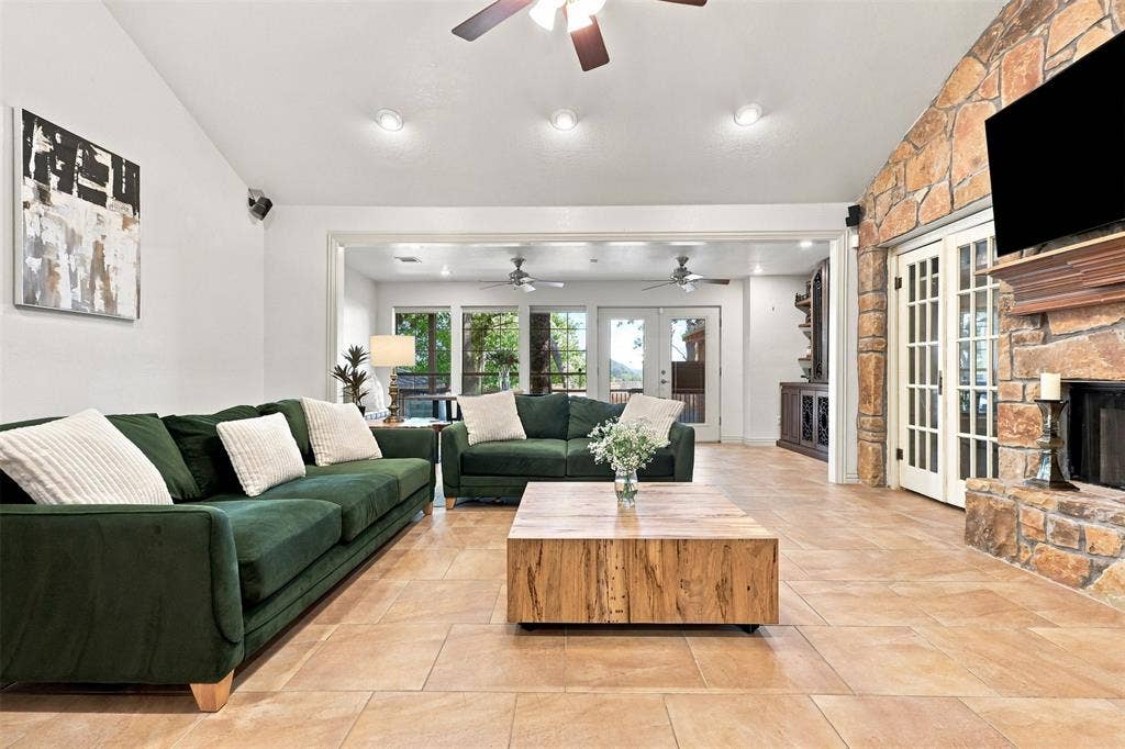 284 Shoreline Drive N, Azle, TX 76020 Stone-clad fireplace with a wood mantle, light tile flooring, recessed lighting, and a ceiling fan