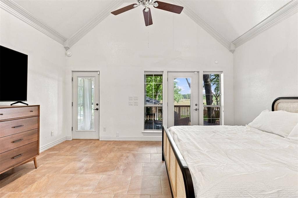 284 Shoreline Drive N, Azle, TX 76020 Vaulted ceiling with crown molding, ceiling fan, tile flooring, and glass-paned doors leading to an exterior deck