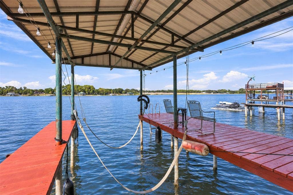 284 Shoreline Drive N, Azle, TX 76020 Covered boat dock with an extended wooden deck, metal canopy, and integrated string lighting