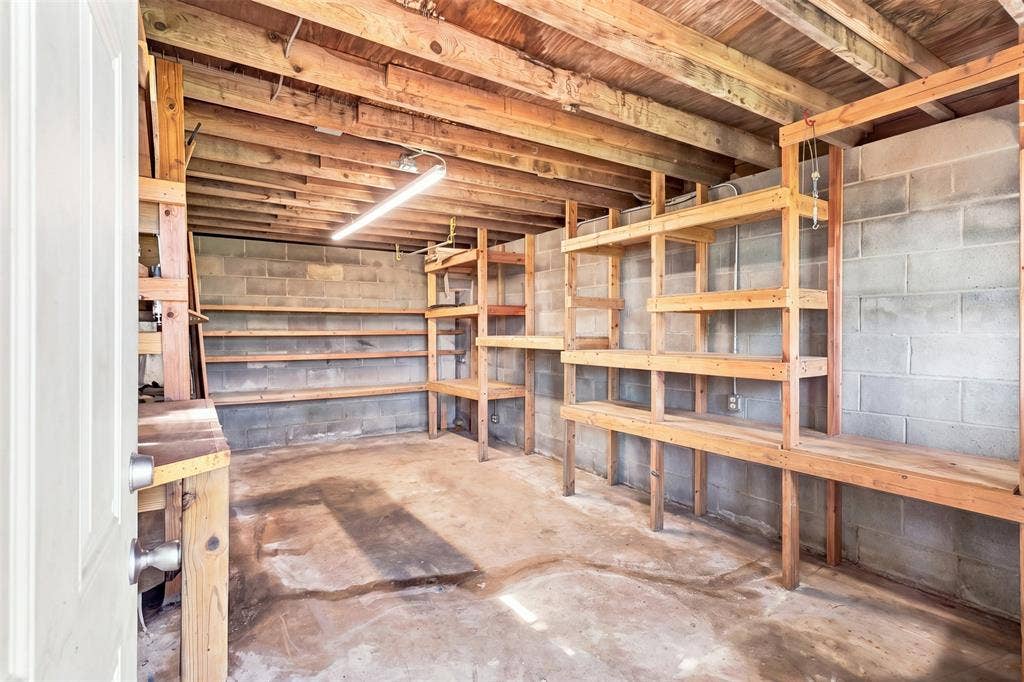 284 Shoreline Drive N, Azle, TX 76020 Boat house with electricity Unfinished room with built-in wooden shelving, exposed wood beam ceiling, concrete block walls, and concrete flooring