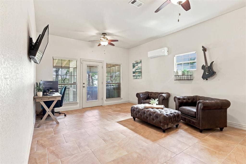 284 Shoreline Drive N, Azle, TX 76020 Tiled flooring, multiple ceiling fans, wall-mounted air conditioning unit, and exterior access via a glass-paneled door