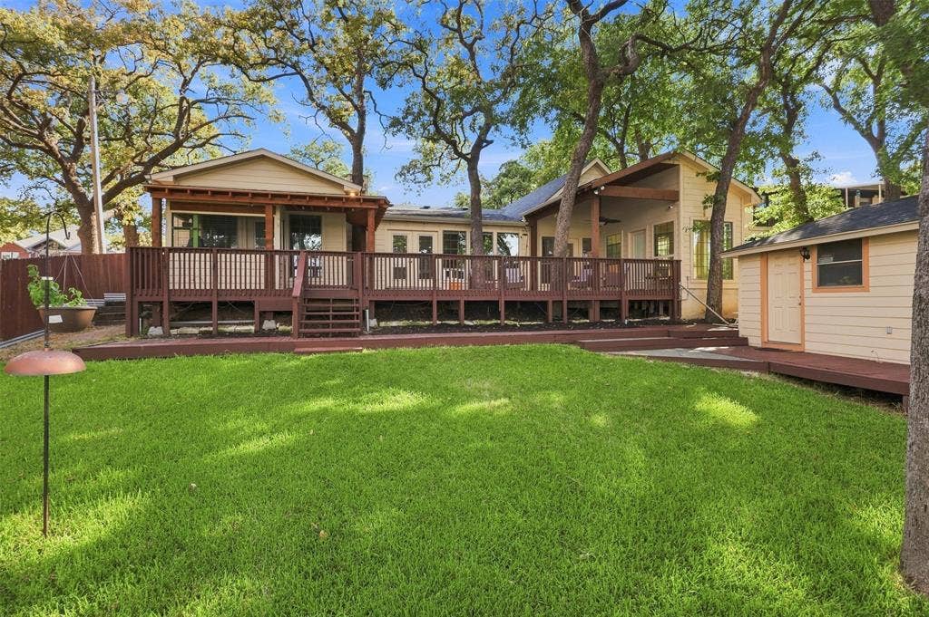 284 Shoreline Drive N, Azle, TX 76020 Expansive green lawn with a multi-level wood deck and a detached storage shed