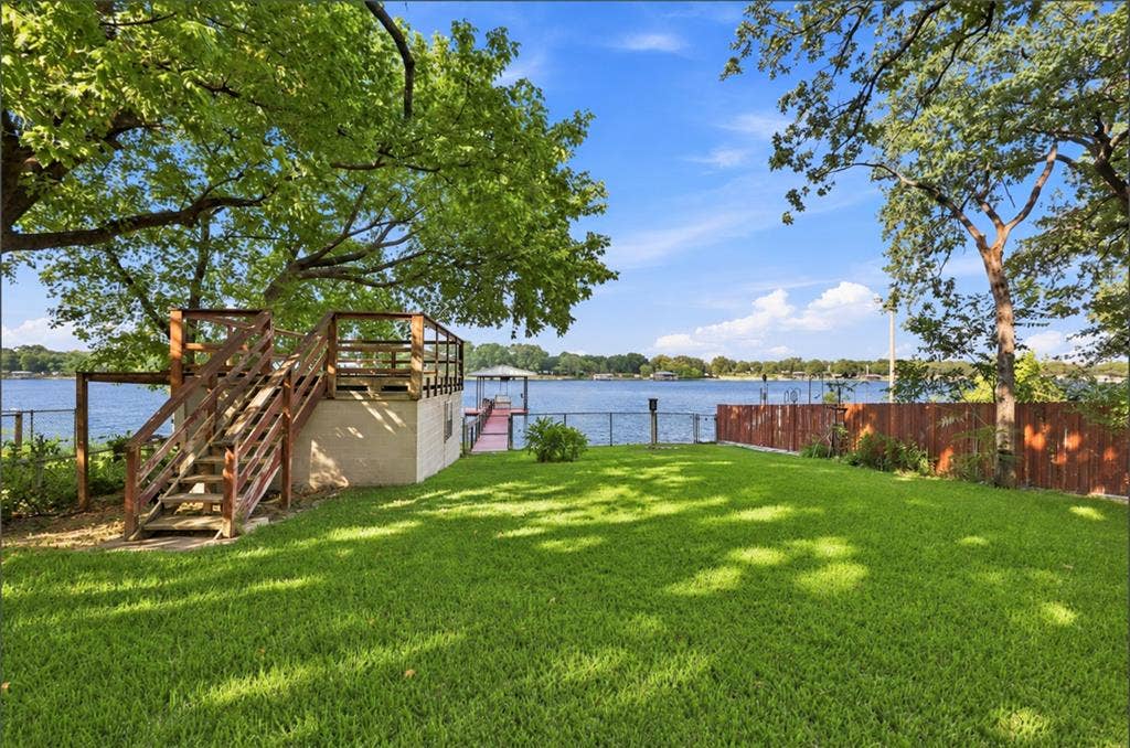 284 Shoreline Drive N, Azle, TX 76020 Expansive lawn with mature trees, a multi-level deck, direct water access, and a private boat dock