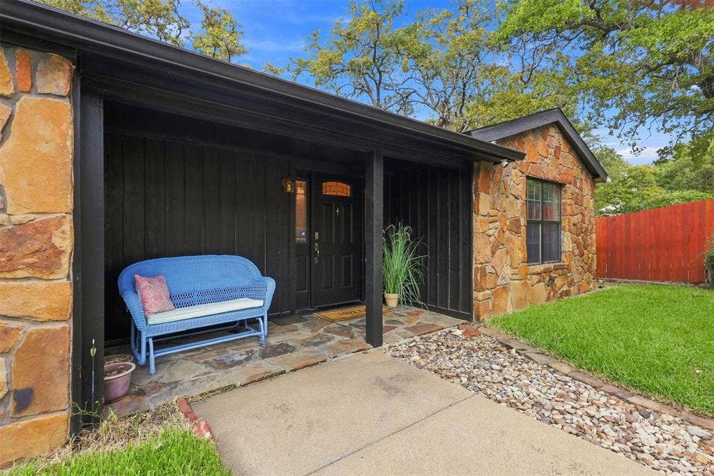 284 Shoreline Drive N, Azle, TX 76020 Stone exterior with black siding, covered entryway, flagstone porch, and a wood entry door