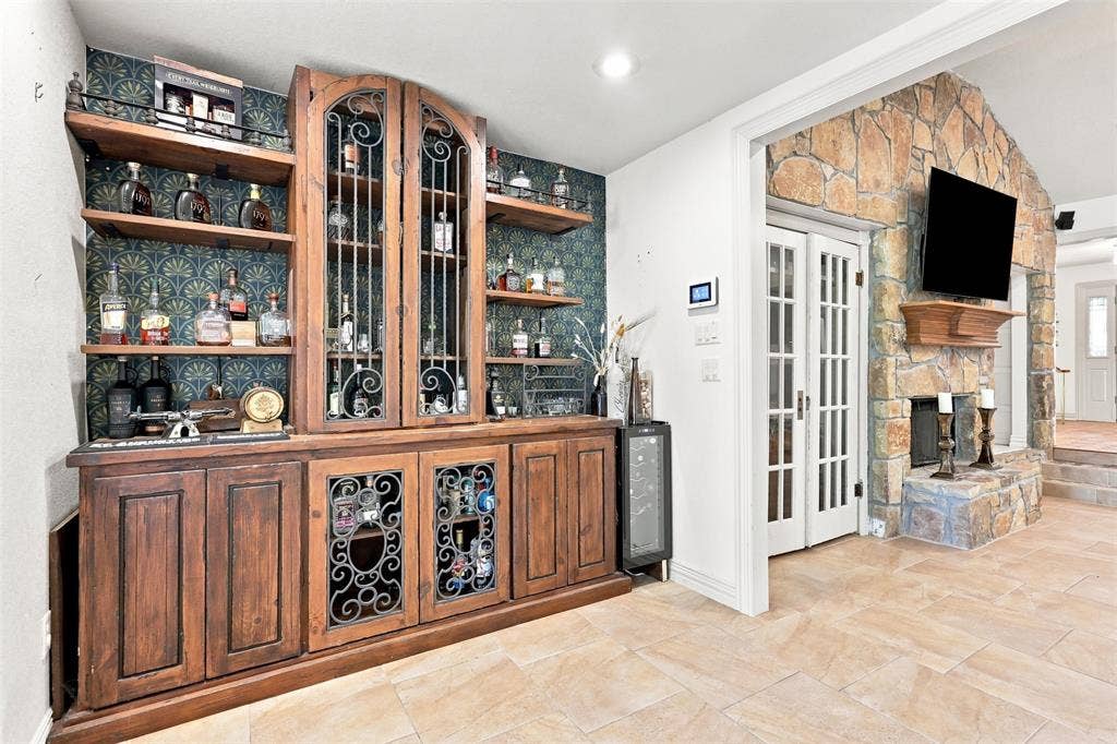 284 Shoreline Drive N, Azle, TX 76020 Built-in wooden cabinetry with ornate glass and metal details, open shelving, and a beverage cooler