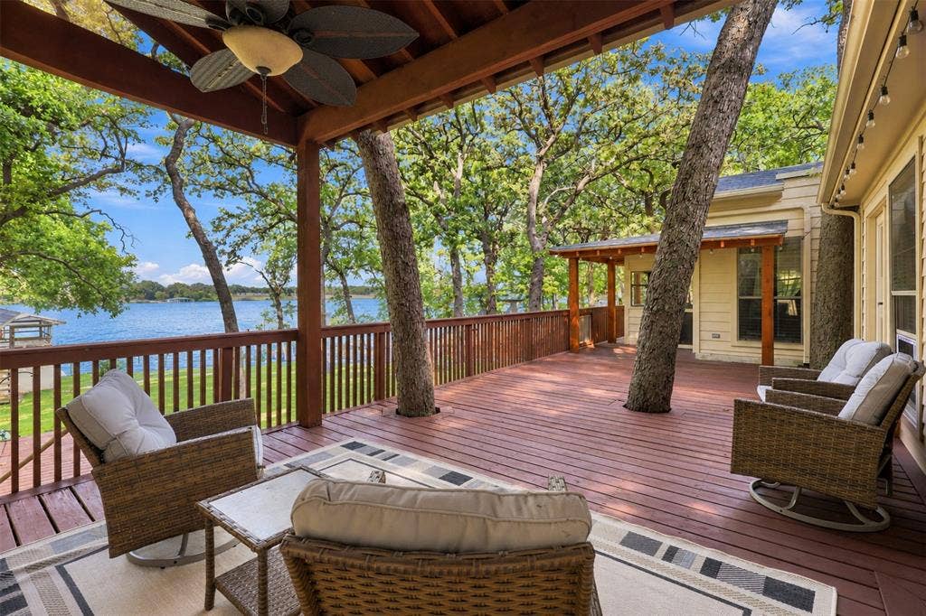 284 Shoreline Drive N, Azle, TX 76020 Expansive wood deck with a built-in ceiling fan, wood railing, and mature trees integrated into the design