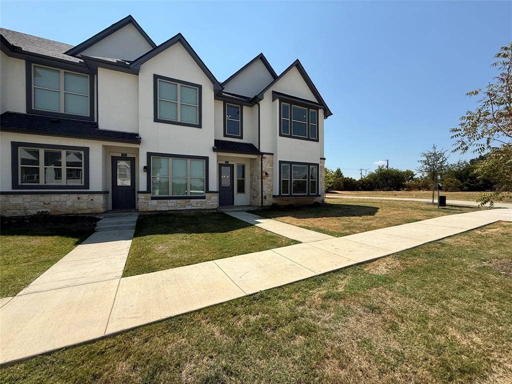373 Buck Ridge Drive, Frisco, TX 75068 Contemporary architectural design with white siding and dark trim, stone veneer accents, and multiple windows
