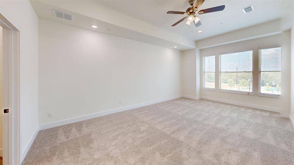 373 Buck Ridge Drive, Frisco, TX 75068 Recessed lighting, ceiling fan, three large windows with horizontal blinds, and neutral carpet flooring