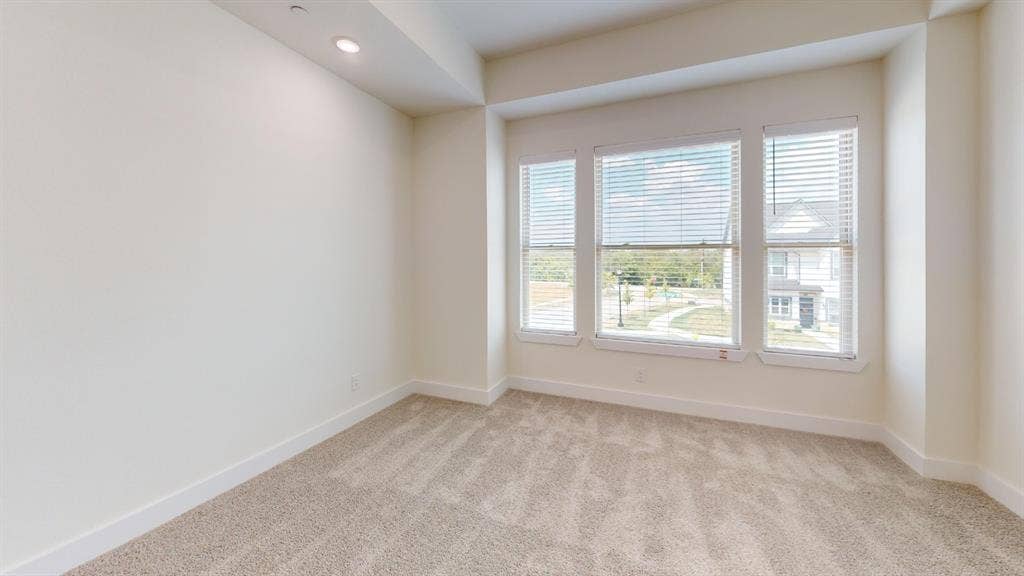 373 Buck Ridge Drive, Frisco, TX 75068 Carpeted flooring, recessed lighting, three large windows with blinds, and neutral wall tones