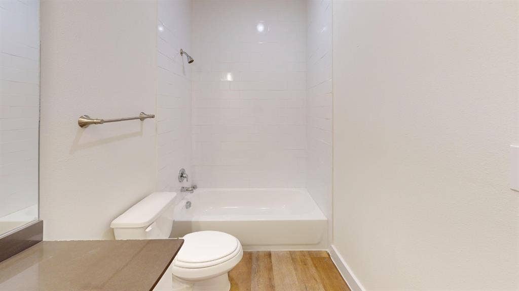 373 Buck Ridge Drive, Frisco, TX 75068 Bathroom featuring a shower/tub combination, wall-mounted showerhead, and wood-finish flooring