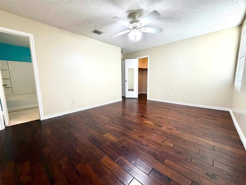 Wood-finish flooring throughout, with a ceiling fan overhead
