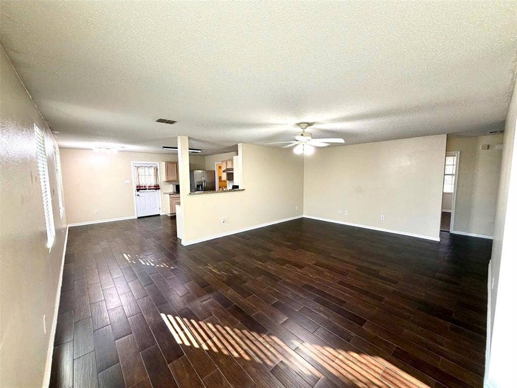 Spacious room with dark wood-finish flooring