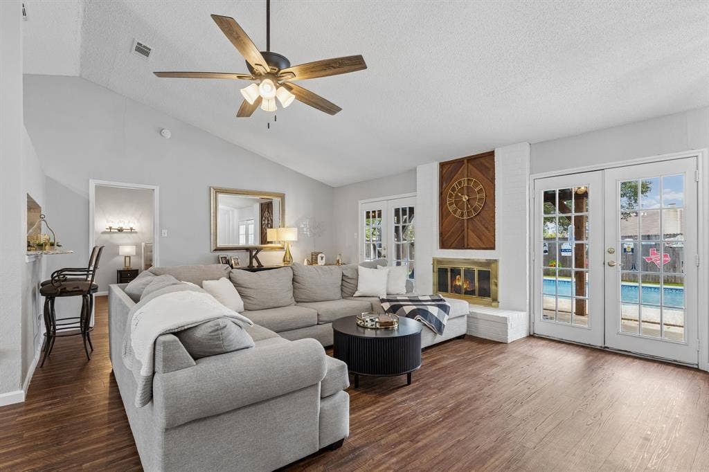 6512 Highview Terrace, Watauga, TX 76148 Living room with fresh paint, tall ceilings, vinyl flooring, wood burning fireplace, and 2 exits leading to back yard
