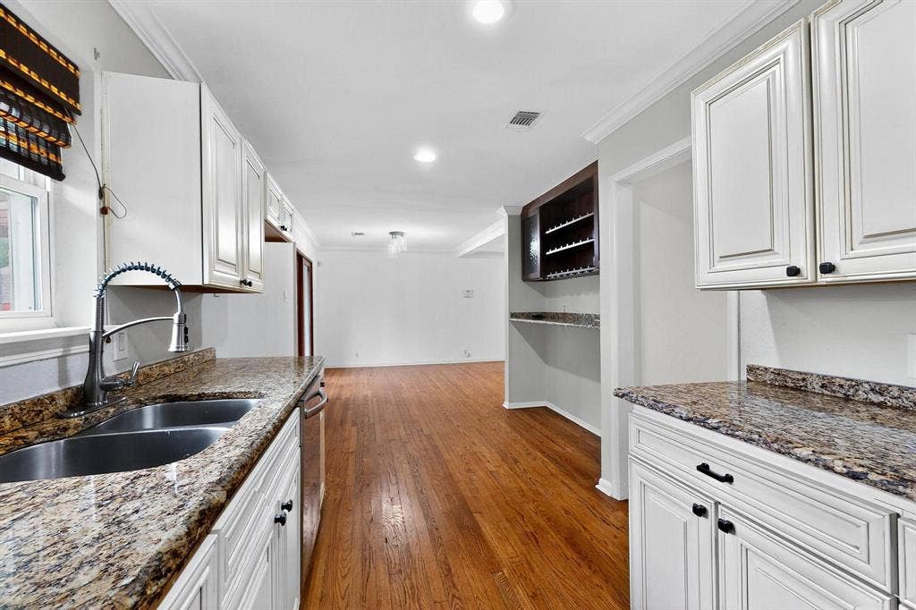 2927 Selma Lane, Farmers Branch, TX 75234 Kitchen with wood finished floors, crown molding, white cabinets, dark stone counters, and recessed lighting