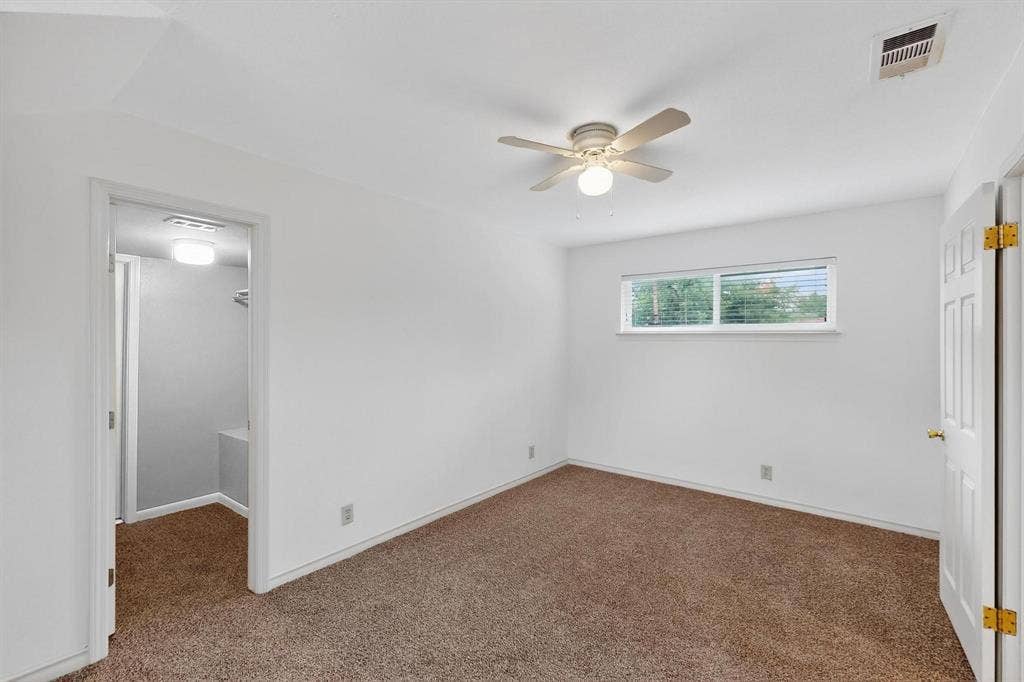 2927 Selma Lane, Farmers Branch, TX 75234 Unfurnished bedroom featuring carpet flooring, a spacious closet, a closet, and ceiling fan