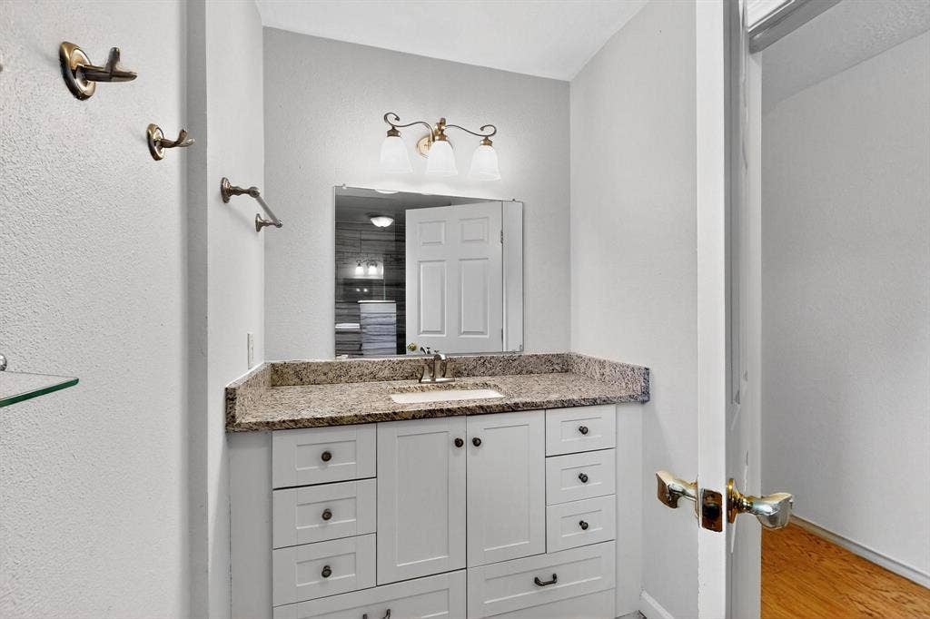 2927 Selma Lane, Farmers Branch, TX 75234 Bathroom featuring vanity and wood finished floors
