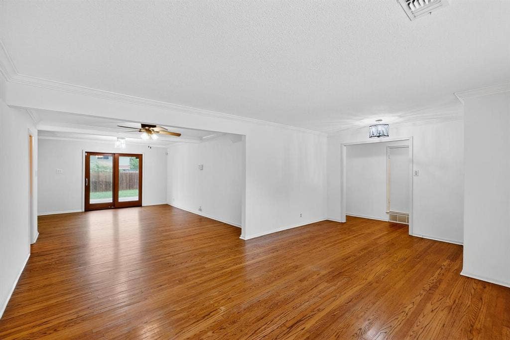 2927 Selma Lane, Farmers Branch, TX 75234 Unfurnished living room with crown molding, light wood finished floors, and ceiling fan