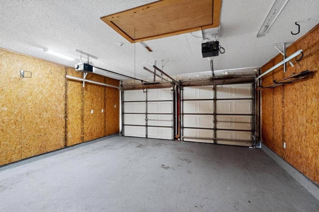 2927 Selma Lane, Farmers Branch, TX 75234 Garage featuring a garage door opener and wooden walls