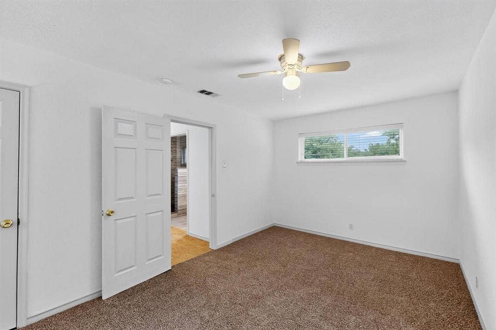 2927 Selma Lane, Farmers Branch, TX 75234 Spare room featuring light colored carpet, ceiling fan, and a smoke detector