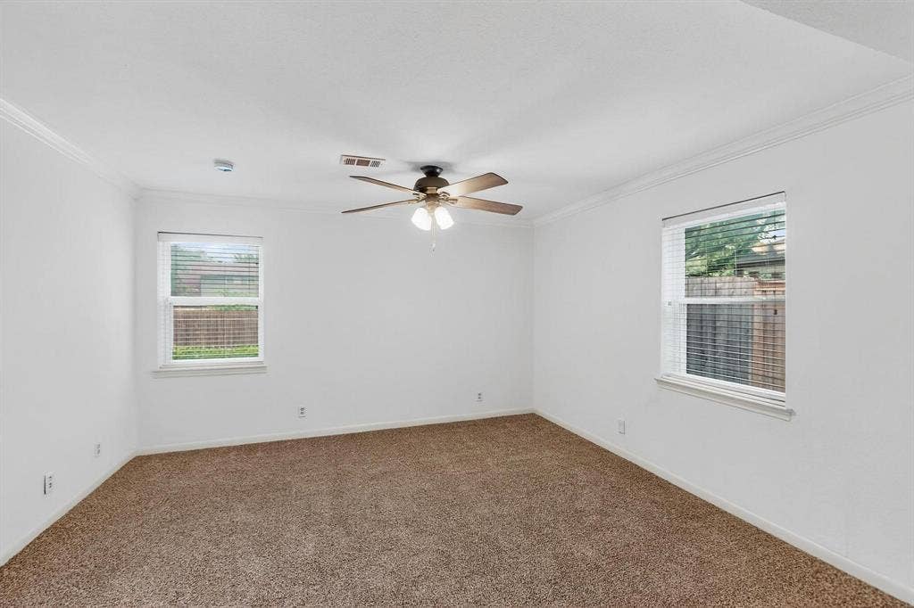 2927 Selma Lane, Farmers Branch, TX 75234 Carpeted spare room with crown molding, healthy amount of natural light, a ceiling fan, and a smoke detector