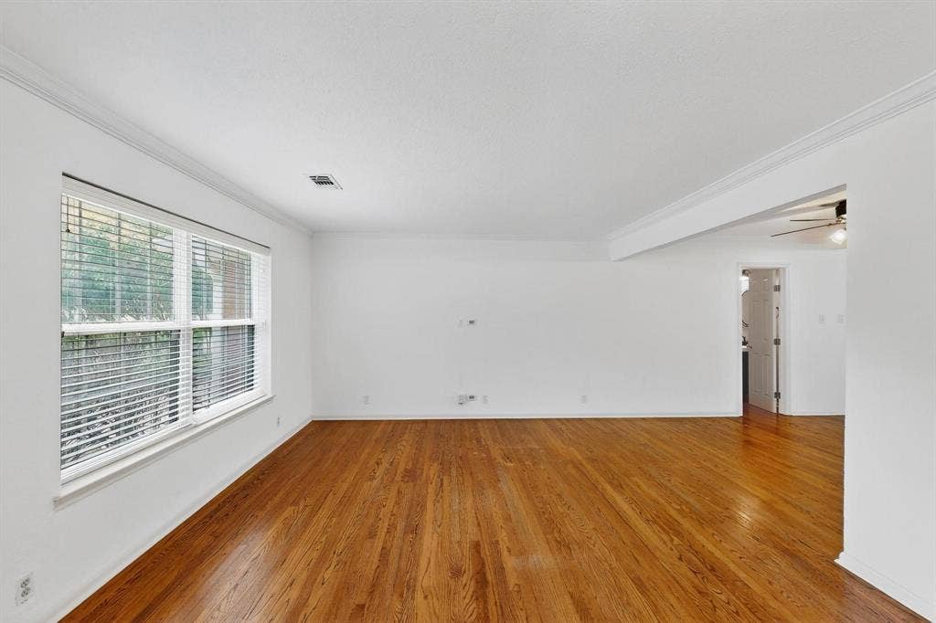 2927 Selma Lane, Farmers Branch, TX 75234 Empty room with ornamental molding, wood finished floors, and ceiling fan
