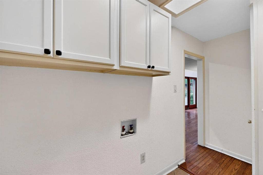 2927 Selma Lane, Farmers Branch, TX 75234 Washroom featuring cabinet space, washer hookup, and wood finished floors
