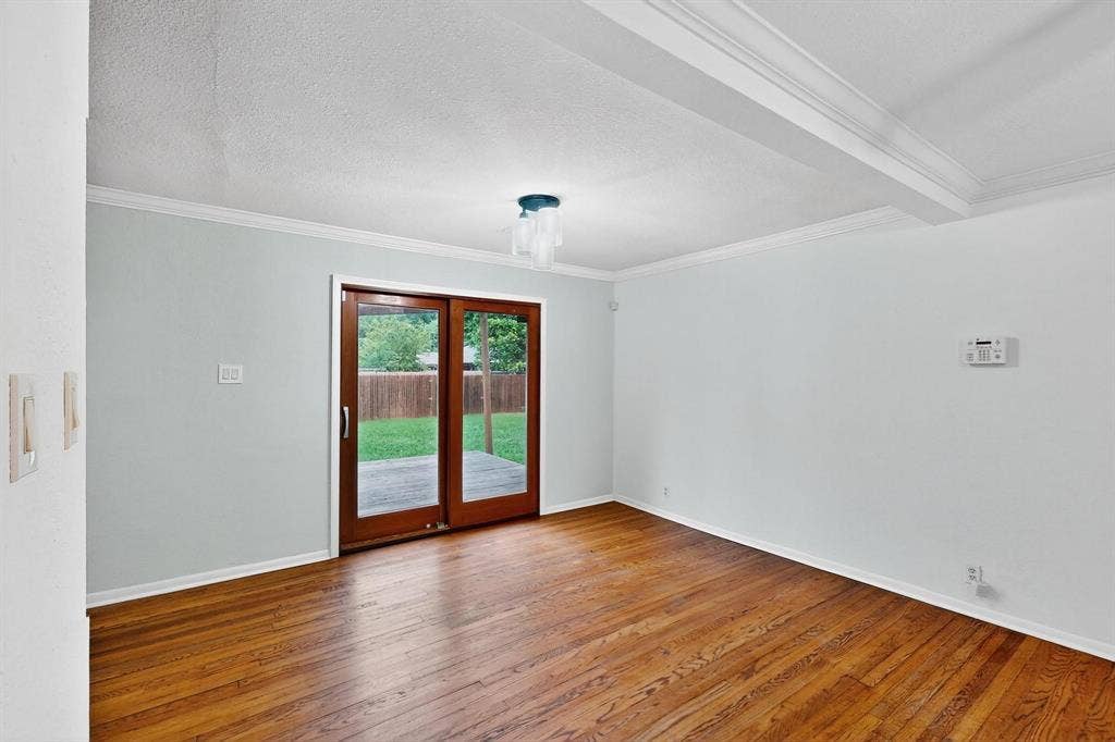 2927 Selma Lane, Farmers Branch, TX 75234 Spare room featuring ornamental molding, hardwood / wood-style flooring, and a textured ceiling