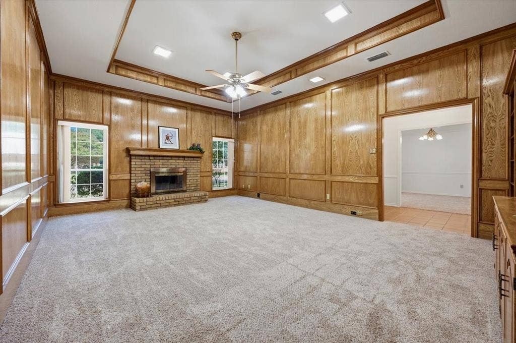 Formal Living room - with lovely custom paneling, fireplace with raised hearth - opposite end of the room features a full wall of custom cabinets and shelving  - fresh carpeting and pad 8/2026 no one has lived on this