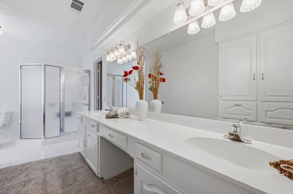 Featuring 2 sinks, walk-in-shower - wall of cabinets for linens and storage - lots of counter space  - view of large walk in shower
