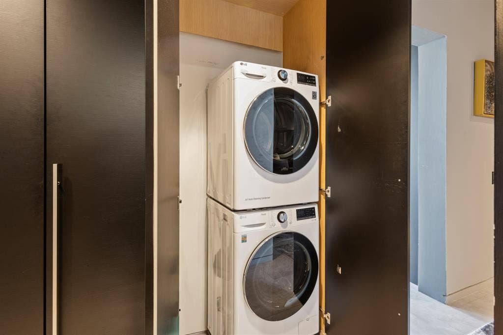 2430 Victory Park Lane, #2401, Dallas, TX 75219 Built-in laundry closet with stacked appliances and dark paneled doors