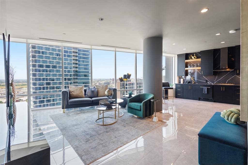 2430 Victory Park Lane, #2401, Dallas, TX 75219 Expansive floor-to-ceiling windows, sleek polished flooring, contemporary kitchen with dark cabinetry, integrated range hood, and distinctive backsplash