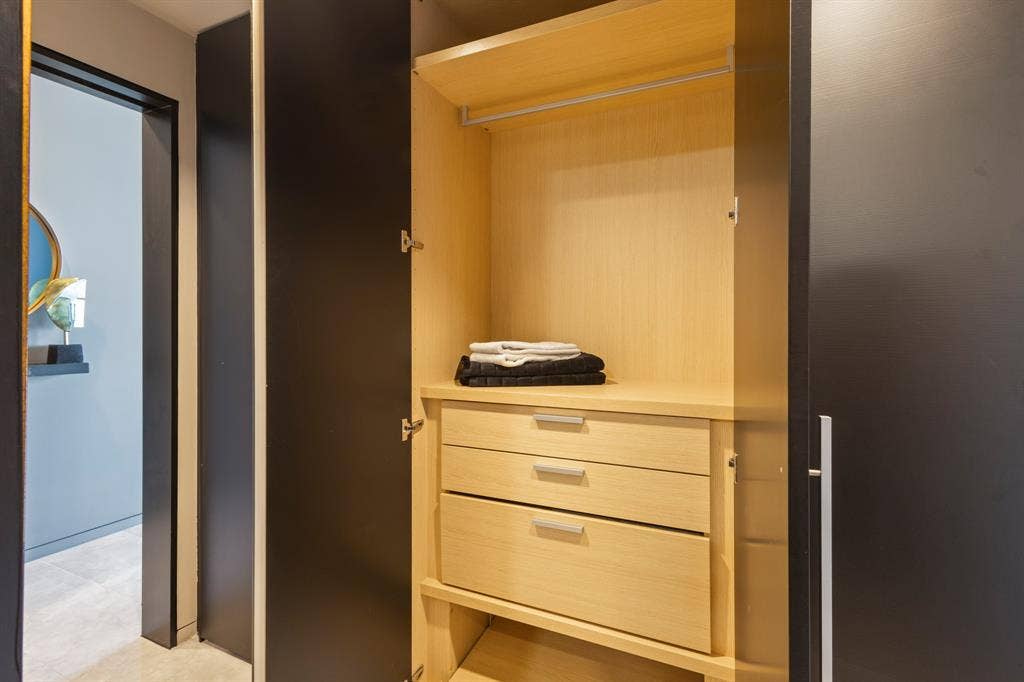 2430 Victory Park Lane, #2401, Dallas, TX 75219 Built-in closet featuring light wood-finish shelving, an upper hanging rod, and two integrated drawers with metal pulls