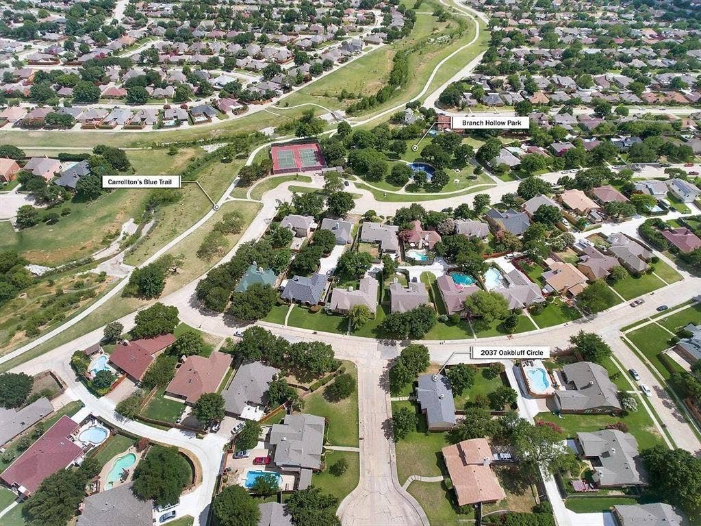Aerial showcasing a residential neighborhood with numerous private swimming pools and mature trees