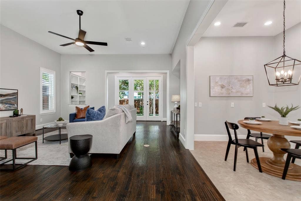 844 Veneto Drive, Allen, TX 75013 Family room with hand-scraped hardwoods, a wall of French doors to the enclosed sunroom, and abuilt-in bookcase niche. The breakfast area connects on the right under a new 2026 lantern pendant.