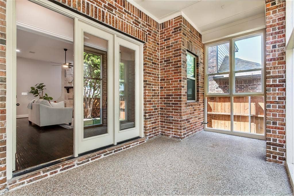 844 Veneto Drive, Allen, TX 75013 Brick-walled sunroom with epoxy flooring, a ceiling fan, and French doors back to the family room.Windows on two sides bring in natural light.