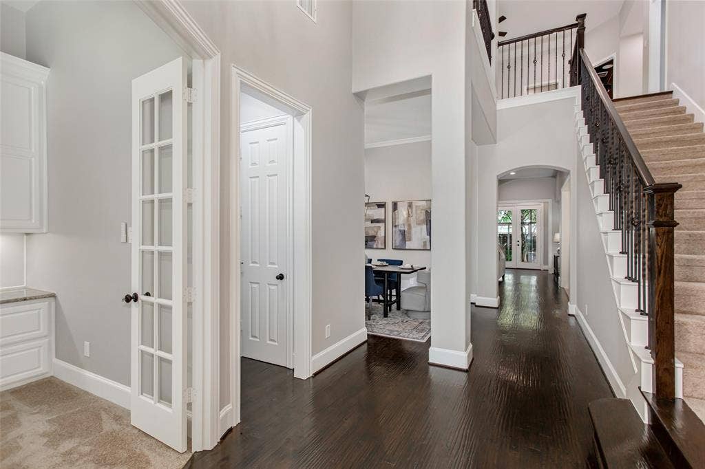 844 Veneto Drive, Allen, TX 75013 Two-story entry with hand-scraped hardwood floors, a wrought iron staircase, and sightlines to theformal dining room and family room. French doors on the left open to the private home office.