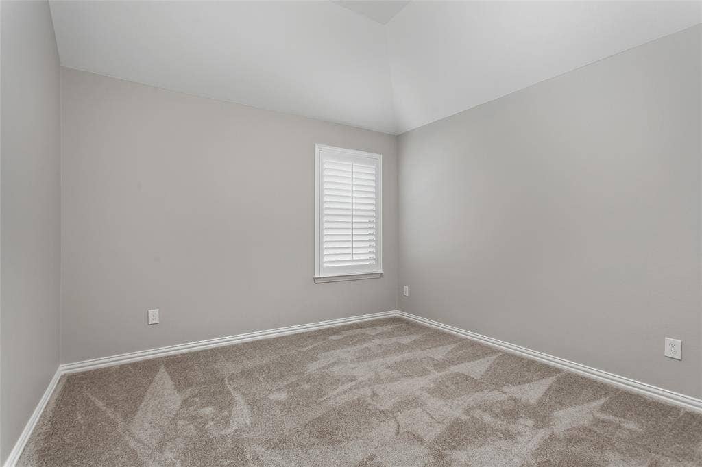 844 Veneto Drive, Allen, TX 75013 One of 3 secondary bedrooms with new 2026 carpet, fresh 2026 paint, and a window with plantation shutters.Vaulted ceiling line and generous closet space.