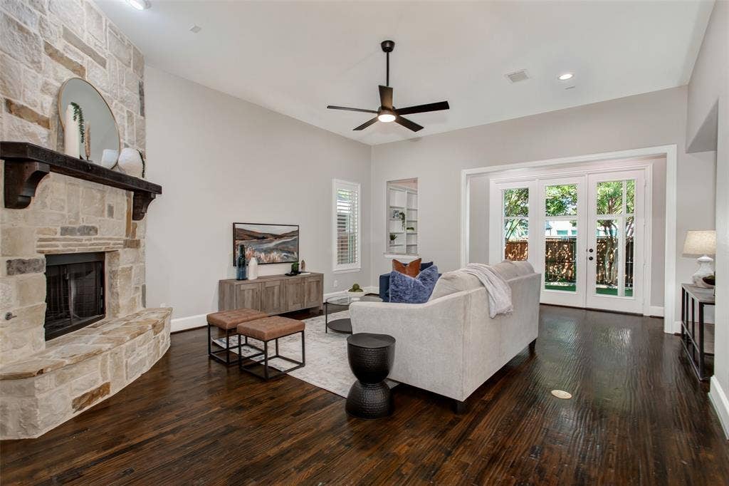 844 Veneto Drive, Allen, TX 75013 A gas-start stone corner fireplace with a raised hearth and dark wood beam mantel anchors the room. Awall of French doors opens to the enclosed sunroom and turf backyard.